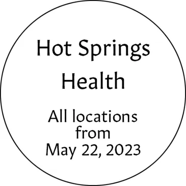 A round button with the words hot springs health on it.