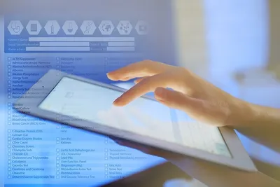 A person using a tablet computer on top of a table.