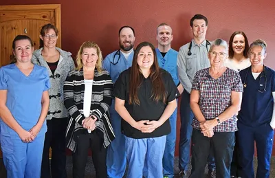 A group of people standing in front of a wall.